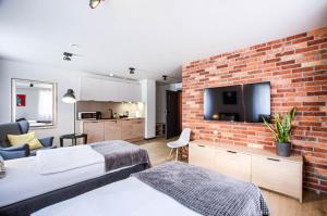 1 dormitorio con 2 camas y pared de ladrillo en Apartamenty Centrum Park en Zielona Góra