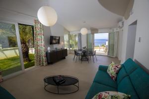 - un salon avec un canapé bleu et une vue sur l'océan dans l'établissement Kafara Resort- Villas and Pool by Lisca Bianca Rental, à Santa Flavia