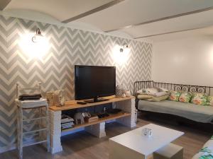 a living room with a flat screen tv and a couch at DOMEK W JERSEY PRZY PLAŻY in Wieleń