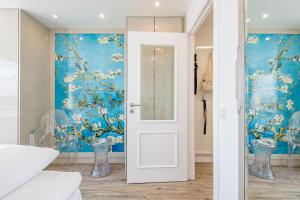 una porta bianca in una stanza con una parete blu di Dünenhof zum Kronprinzen Penthouse App 115 a Wenningstedt Altre 30 foto