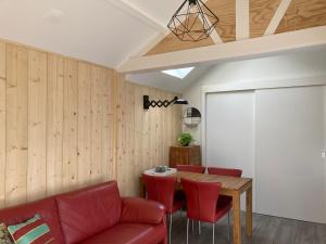 a living room with a red couch and a table at Vakantiehuis 't Laaisterplakky zonder drempels in Oude Bildtzijl