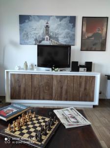 a living room with a chess board and a tv at La casa di Giulio - holiday home in Isola delle Femmine