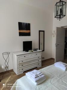 a bedroom with a white dresser with a television on it at La casa di Giulio - holiday home in Isola delle Femmine