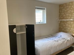 a small bedroom with a bed and a window at Vakantiehuis 't Laaisterplakky zonder drempels in Oude Bildtzijl
