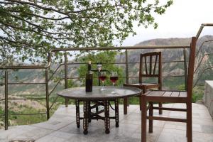 - une table avec deux verres de vin et deux chaises dans l'établissement Hotel Euphrat Nemrut, à Karadut