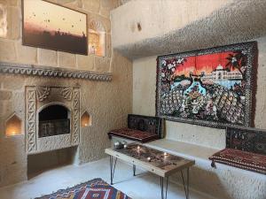 a living room with a table and a painting on the wall at Nox Cave Hotel in Nevşehir