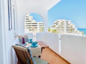 a table and chairs on a balcony with a view of the ocean at VIVE BENALMÁDENA Apartamento La Paloma, PLAYA a 100m in Benalmádena