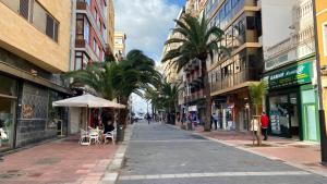 an empty city street with palm trees and buildings at Apartamento beach house in Las Palmas de Gran Canaria