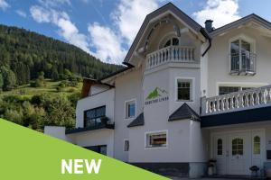 a white house with a hill in the background at Mountain Living Ski-in & Ski out Silvretta Sommer Card Including in See