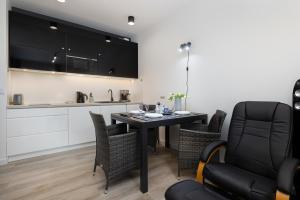 a kitchen and dining room with a table and chairs at Platinium Apartment by Renters Prestige in Rewal