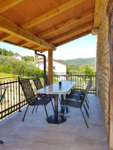 a table and chairs on a patio with a wooden roof at Apartments Villa Irena in Koper
