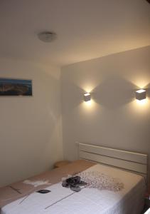 - une chambre avec un lit et deux lumières sur le mur dans l'établissement Appartement en RDC au cœur du Grau du Roi, au Grau-du-Roi