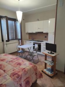 a bedroom with a bed and a table and a kitchen at B&B Gli amici del tubarello in Roseto degli Abruzzi