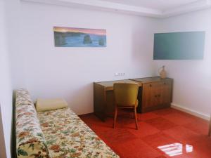 a bedroom with a bed and a desk and a television at Ferienhaus Niesky in Niesky