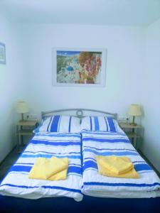 1 cama con sábanas de rayas azules y blancas y almohadas amarillas en Ferienhaus Niesky, en Niesky