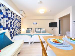 Habitación de hotel con 2 camas y mesa de comedor en ケイアイコンホテルズ ふくしあ801 en Chikusachō