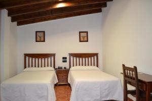 two beds in a room with white walls at Rincón del Abade in Encinasola +15 photos
