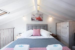 a bedroom with a bed with pink and white pillows at AD HOMES in Agios Gordios