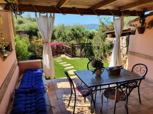 a patio with a table and a blue couch at Casa Sole in Villasimius