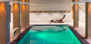 uma piscina no meio de uma sala com uma cadeira em Hotel Wiesnerhof em Vipiteno