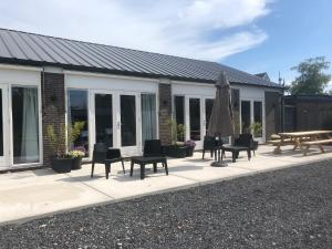 a patio with chairs and a table and an umbrella at BnB Purmerland in Purmerend