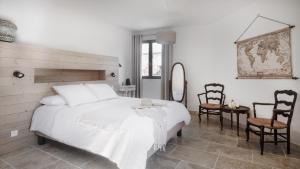 a bedroom with a white bed and a table and chairs at L'Ostal Saint Hilaire d'Ozilhan - Bed & Breakfast - Spa in Saint-Hilaire-dʼOzilhan +50 photos