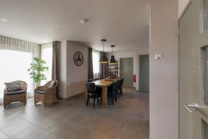 a dining room and living room with a table and chairs at Familyhome - Oostkapelsweg 32 Serooskerke 'Reiger' in Serooskerke