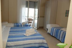 2 Betten mit Handtüchern auf einem Zimmer in der Unterkunft B&B La Regina di Rimini in Rimini