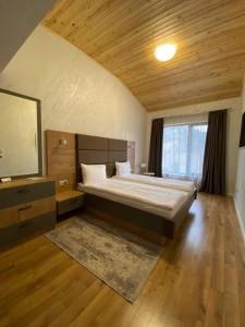 a bedroom with a bed and a flat screen tv at Villa Dea & Villa Ina - Villas & SPA Park in Velingrad in Velingrad