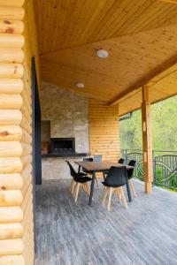 une terrasse en bois avec une table et des chaises. dans l'établissement Villa Dea & Villa Ina - Villas & SPA Park in Velingrad, à Velingrad