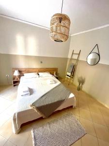 a bedroom with a large bed and a chandelier at Bocca house near Athens Airport in Spata