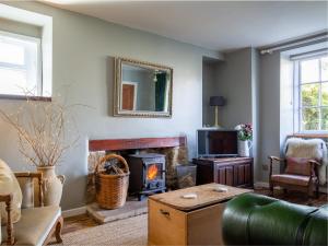 a living room with a fireplace and a couch at Walkley Wood Cottage in Nailsworth