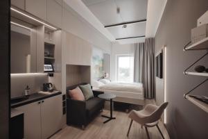 a small room with a bed and a chair at VALO Hotel & Work Helsinki in Helsinki +37 photos