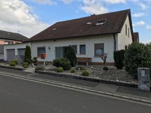 a white house with a landscaping in front of it at Ferienwohnung Treutlein in Thüngersheim