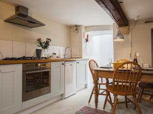 una cucina con tavolo e sedie e una sala da pranzo di Walkley Wood Cottage a Nailsworth