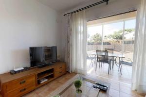 a living room with a television and a table with chairs at Anju villasVILLA MARGA VILLA AT 100 METERS FAR OF THE BEACH in Corralejo