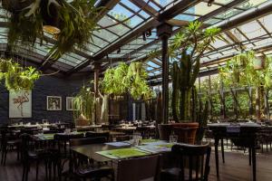 a restaurant with tables and chairs and plants at Areadocks Boutique Hotel in Brescia
