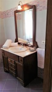 uma casa de banho com um lavatório e um espelho grande em Elio&Mina - appartamento con vista mare em Pantelleria