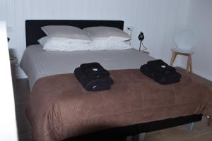 a bed with two black bags sitting on top of it at BnB Purmerland in Purmerend