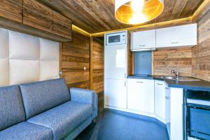 a living room with a couch and a kitchen at Magnifique petit studio 2-3 personnes dans l'Hyper Centre skis aux pieds vue front de neige in Val dʼIsère