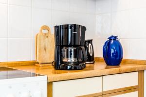 a coffee maker on a kitchen counter with a blue vase at Ferienwohnung Köln-Altstadt-Nord in Cologne