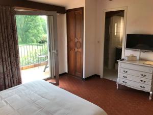 a bedroom with a bed and a television and a sliding glass door at GOLF CLUB D'UZES in Uzès