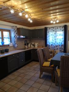 a kitchen with black cabinets and a table and chairs at Reithamer Bergfensterl in Warngau