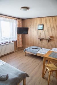 Habitación con 2 camas y mesa. en Tatrzańskie Kwatery, en Bukowina Tatrzańska