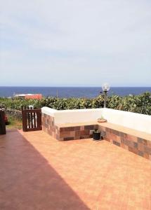 a bench on a patio with the ocean in the background at Elio&Mina - Dammusi e Appartamenti con vista mare in Pantelleria