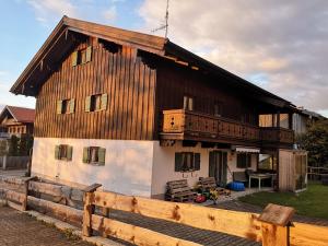 a large wooden house with a fence in front of it at Reithamer Bergfensterl in Warngau
