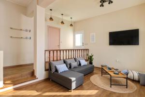 a living room with a couch and a tv at Rementzo Apartment in Symi