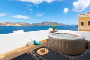 a hot tub on a balcony overlooking the ocean at Rementzo Apartment in Symi