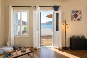 a living room with a door open to the ocean at Rementzo Apartment in Symi