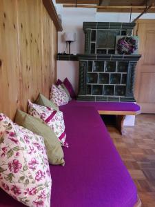 um quarto com uma cama roxa com almofadas em Reithamer Bergfensterl em Warngau